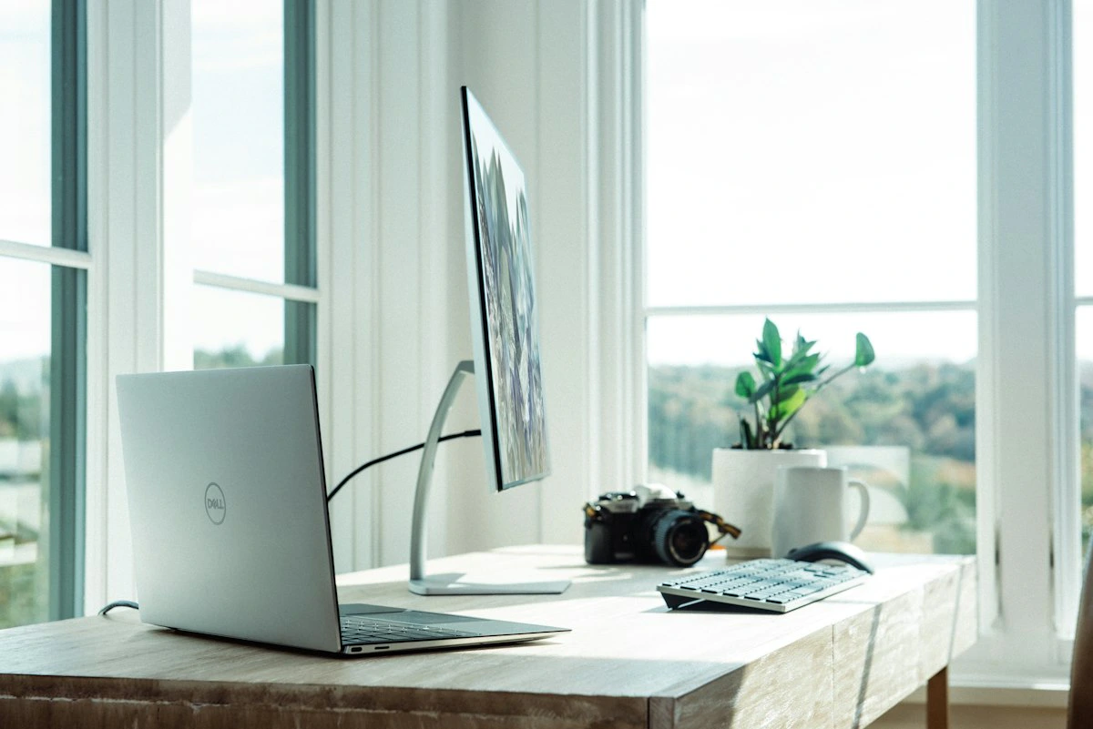 Escritório doméstico organizado com mesa, computador e cadeira em ambiente iluminado