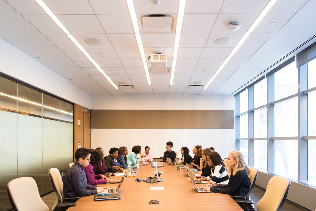 Grupo de pessoas colaborando em sala de reunião corporativa moderna